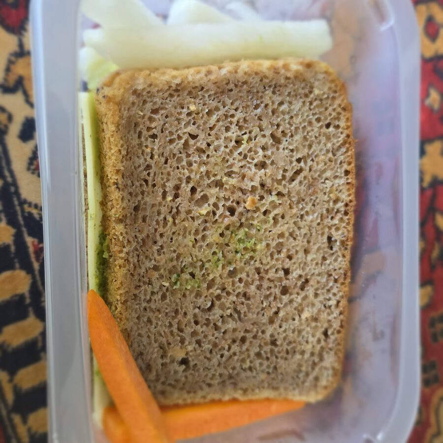 Kanapka razowa z pesto z rukoli i pestek dyni, roszponką i serem edamskim, słupki warzyw