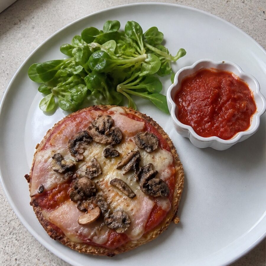 Mini pizza na pełnoziarnistym spodzie z pieczarkami, szynką i serem mozzarella, sos pomidorowy bez cukru