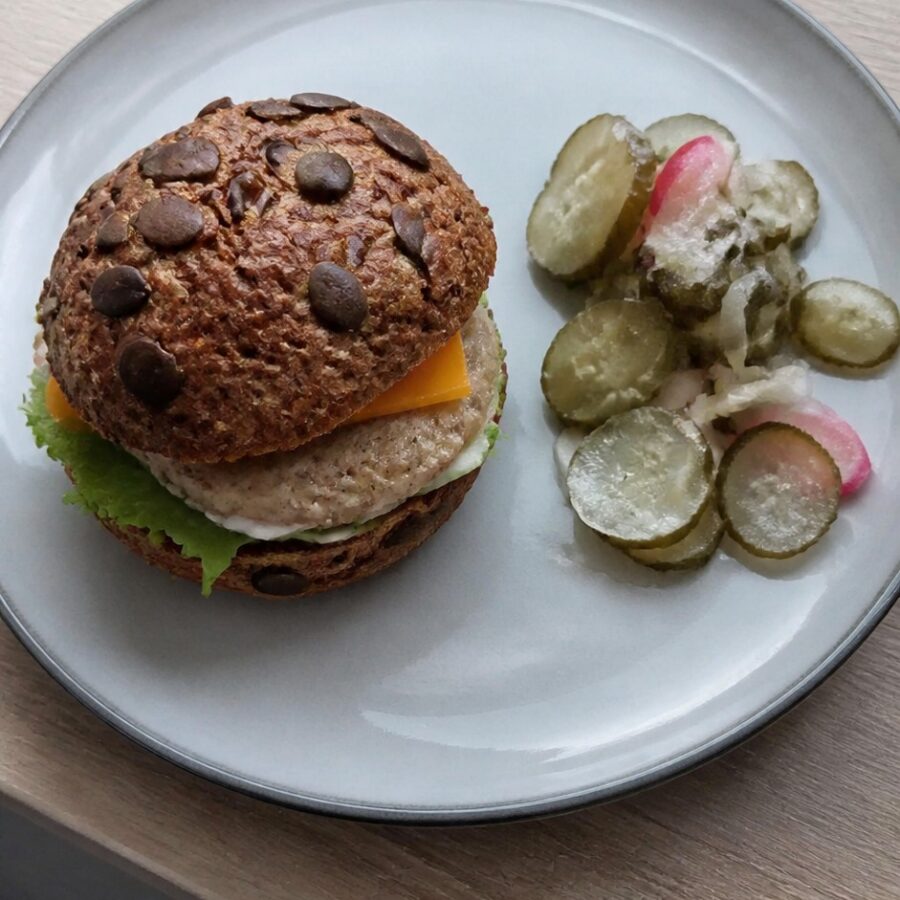 Drobiowy burger z serem cheddar, sałatą i dipem czosnkowym, surówka z ogórków kiszonych z cebulką