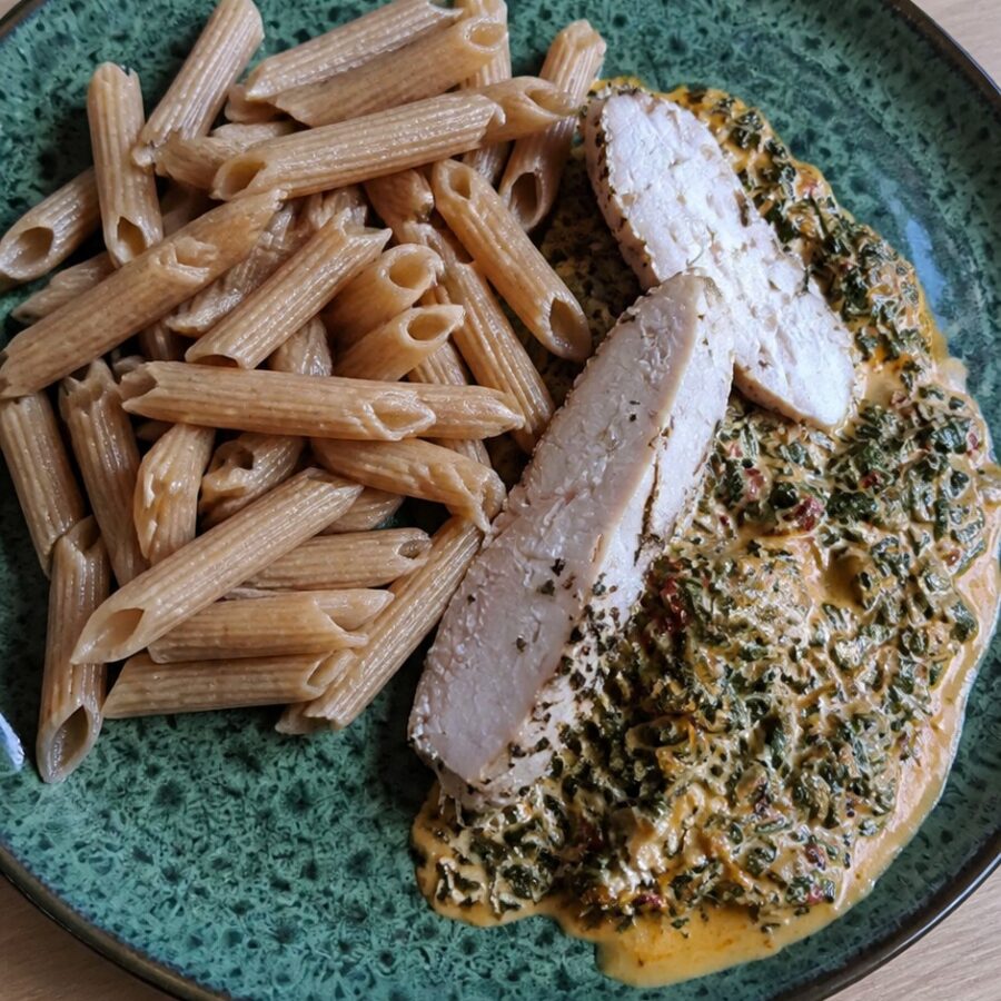 Pełnoziarniste penne w pikantnym śmietanowym sosie z ndują i szpinakiem, plastry kurczaka