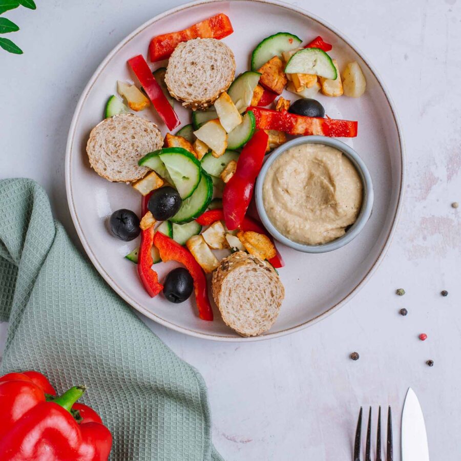 Śniadaniowy bowl z pieczonym halloumi, papryką, ogórkiem i oliwkami, hummus, bagietka graham