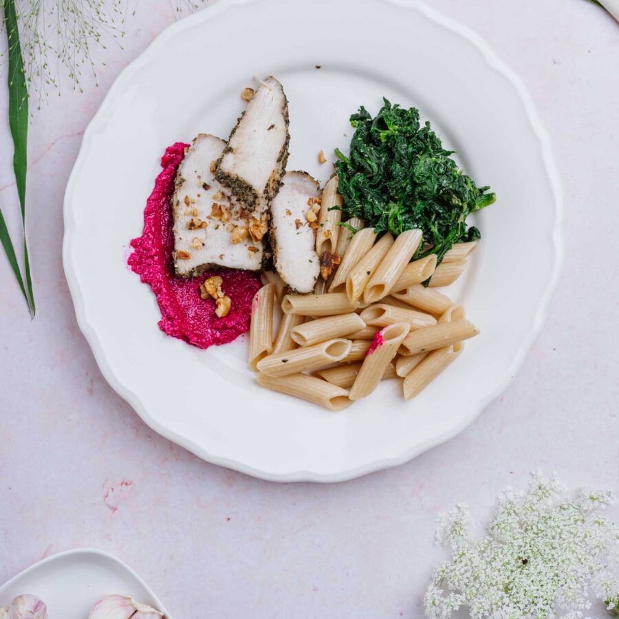 Pierś z kurczaka w pesto buraczkowym z razowym penne i orzechami włoskimi, szpinak z czosnkiem niedźwiedzim